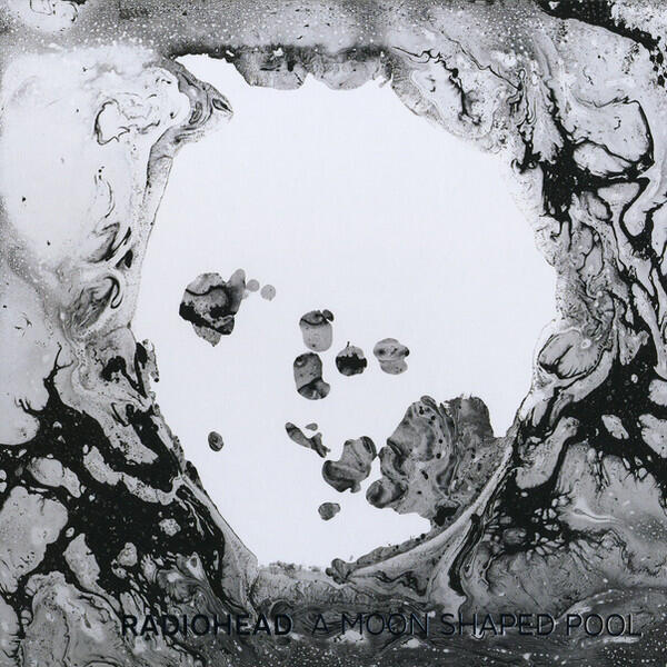 The cover of the album 'A Moon Shaped Pool'. It is a black and white photo, with realistic wave patterns and a white center.